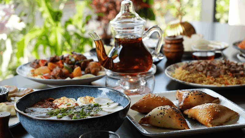 Table avec de nombreux plats ouïghours et une théière